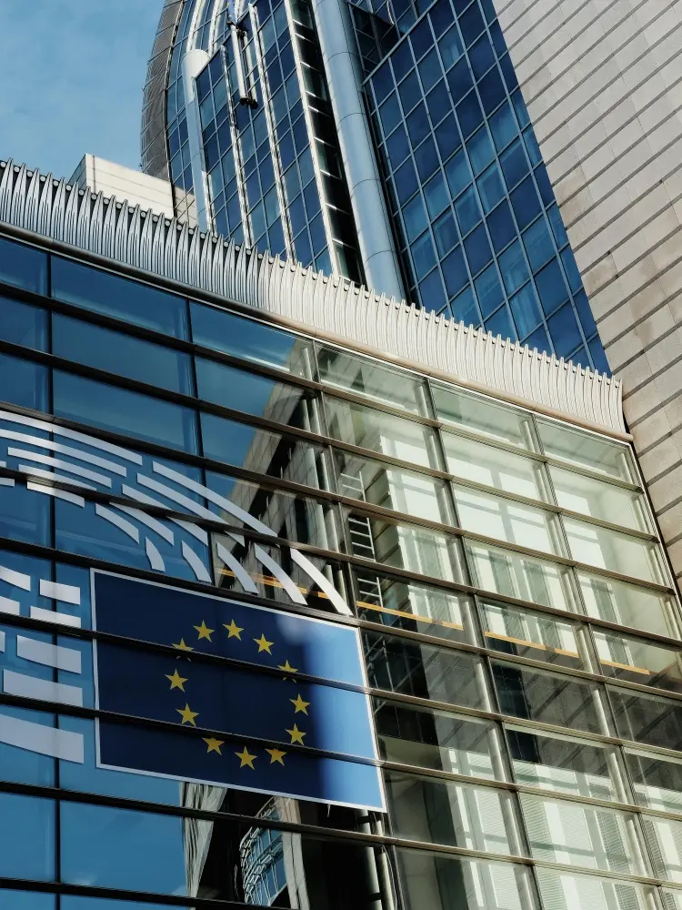 欧盟机构办公楼与欧盟旗帜，展示欧拍基地提供欧盟合规保障、GDPR 数据合规与授权交付服务